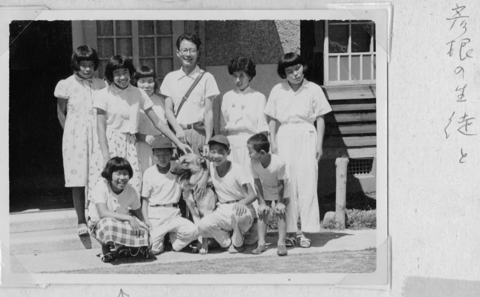 「彦根の生徒と」という河相さんの家族のメモ書きがある記念写真。背景は当時の校舎か（1957年ごろ）