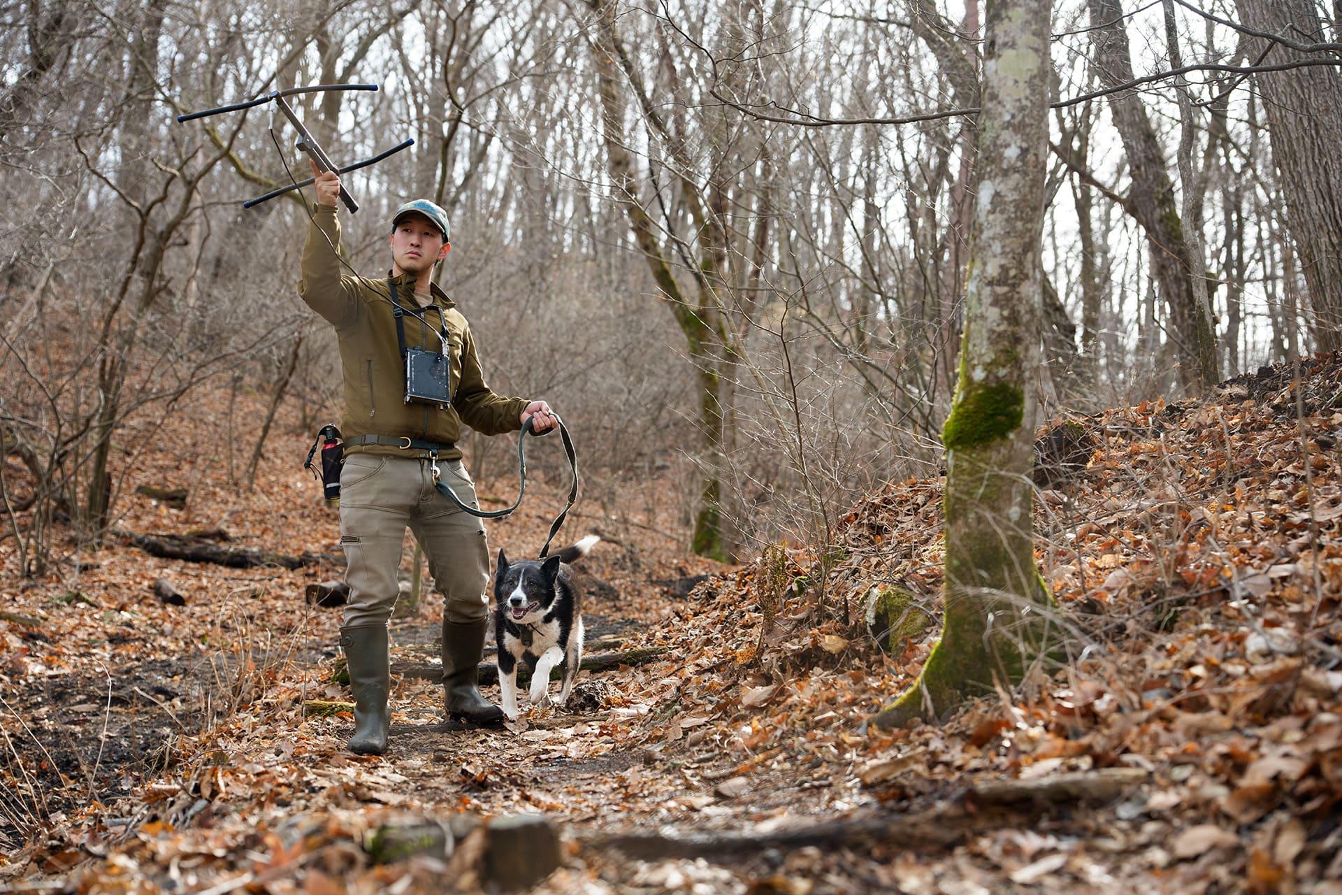 受信機を手にパトロールし、発信器をつけたクマの行動を把握する
